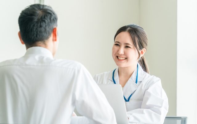 患者に笑顔で接する女性医師